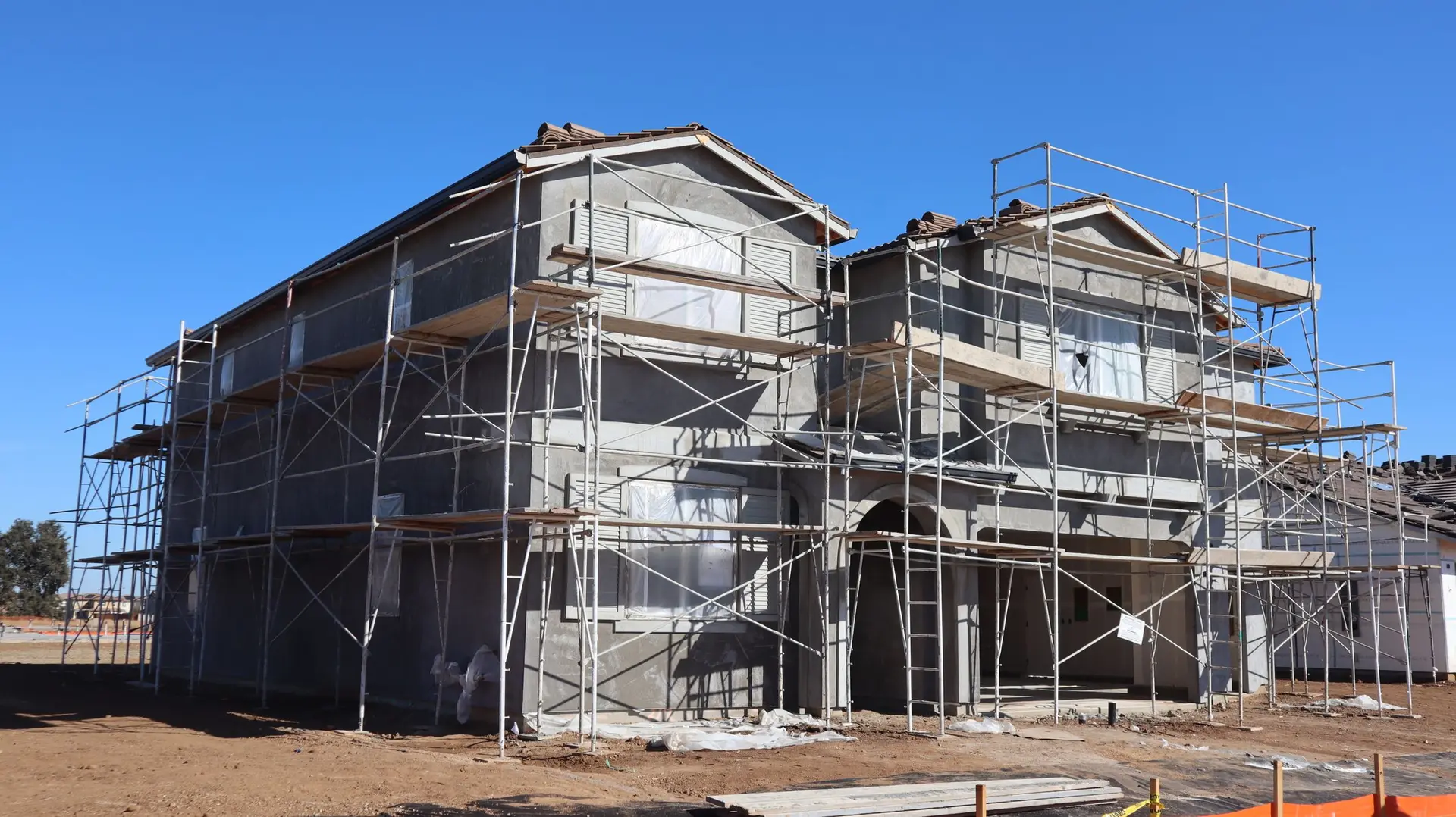 Two-story house framed and wrapped in scaffolding during construction