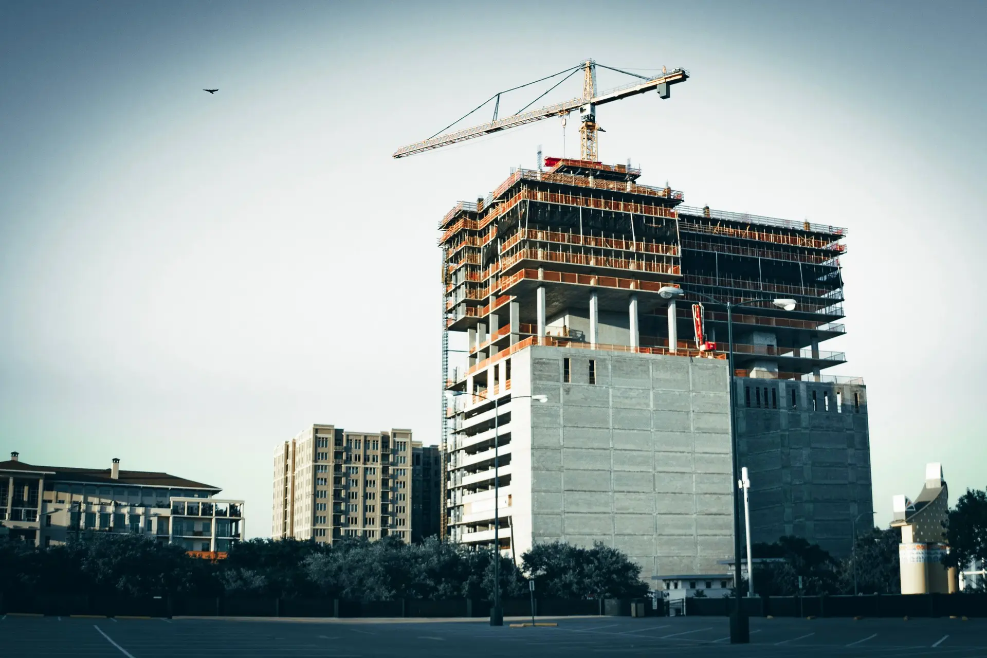 Concrete tower under construction with a crane on top