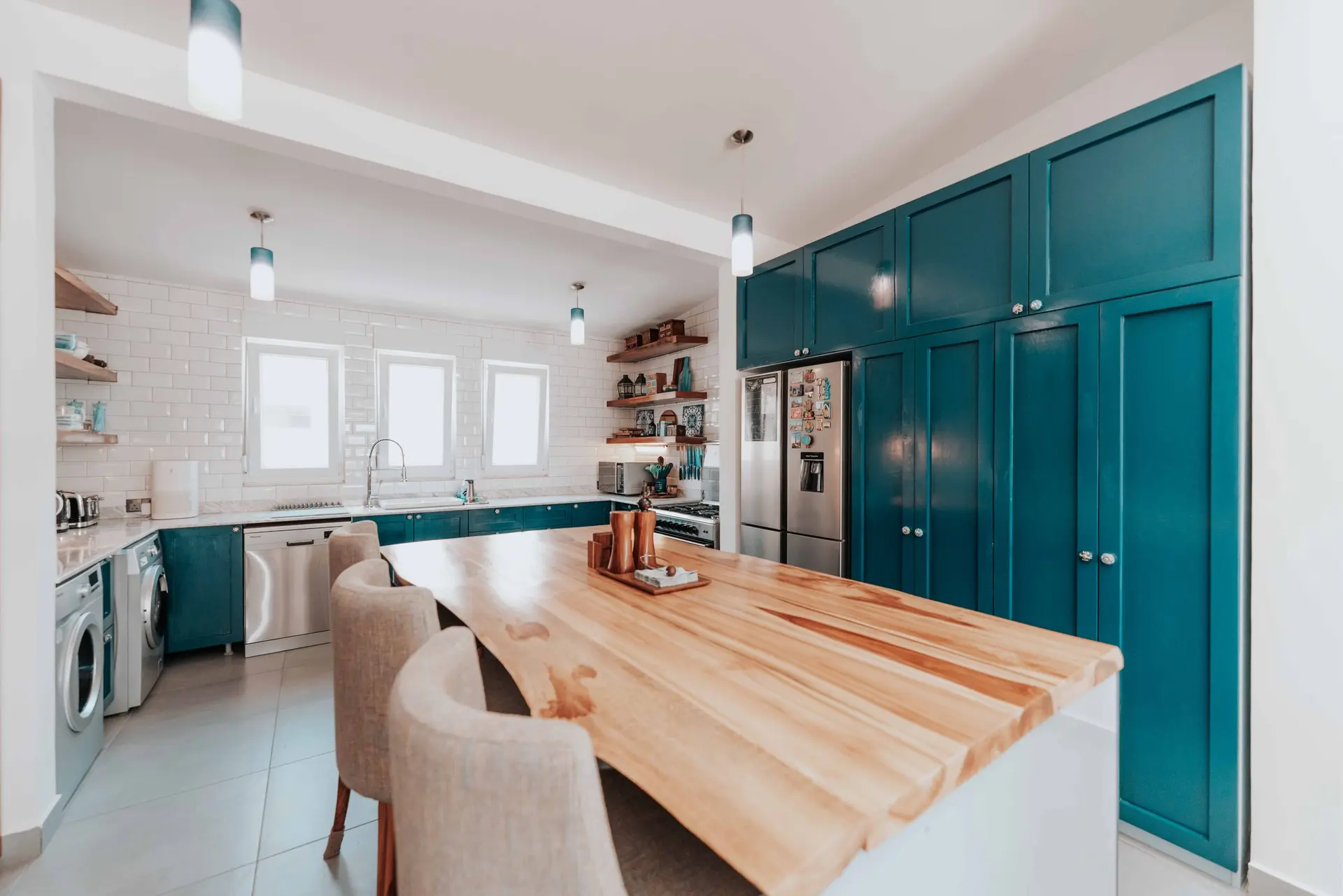 Kitchen with teal cabinets and a long butcher block island