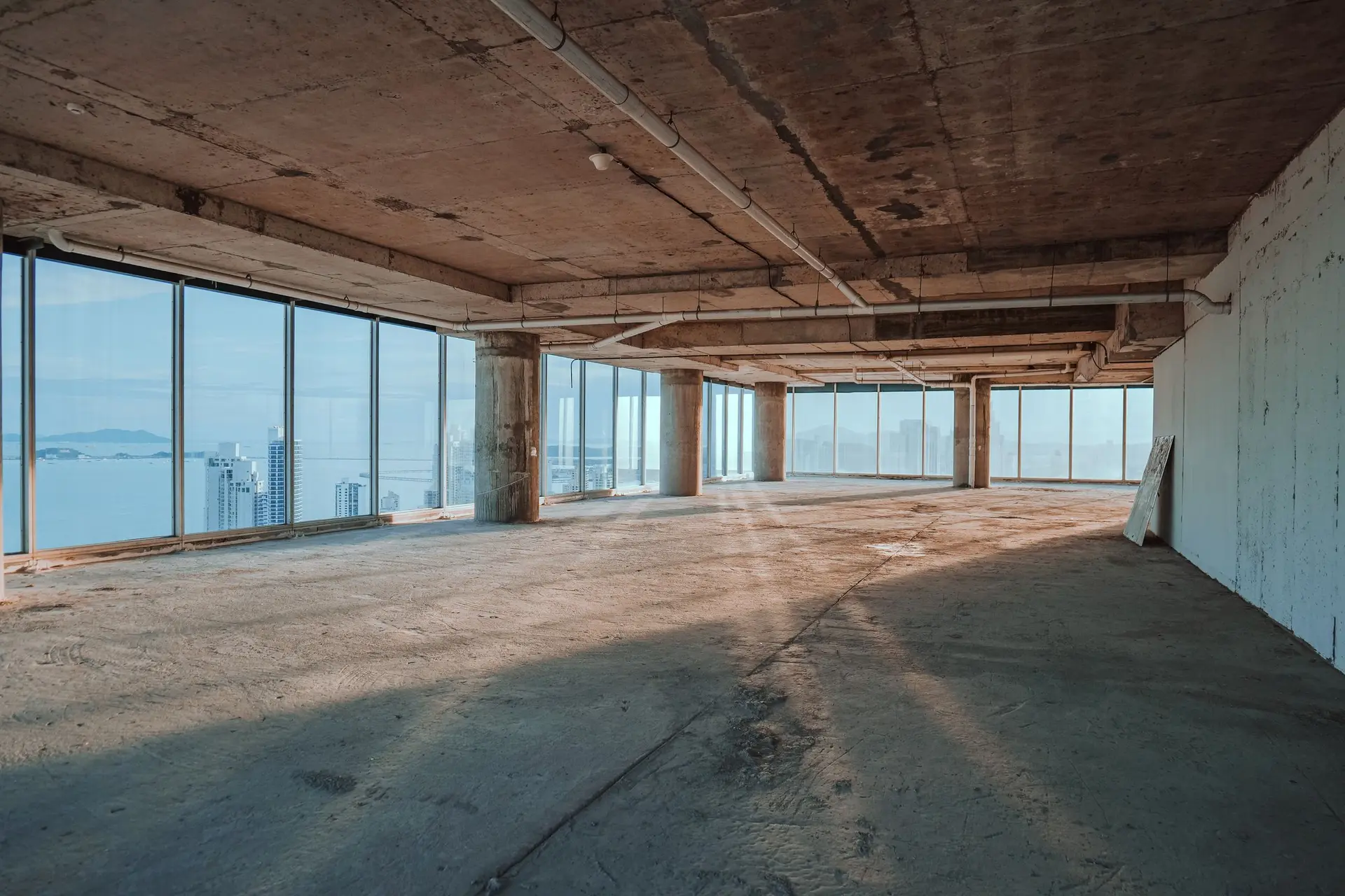 Empty office floor shell with bare concrete and full-height windows